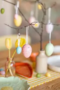 painted eggs hanging from branch