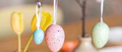 painted eggs hanging from branch