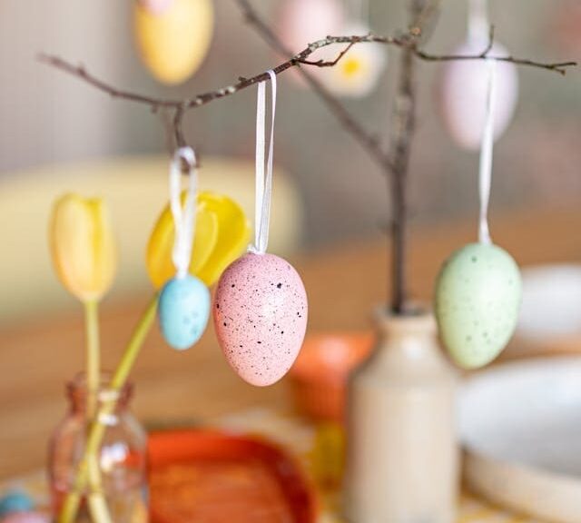 painted eggs hanging from branch